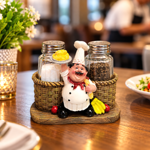 Close-up of two clear salt and pepper shakers with a chef figurine holder