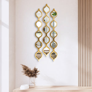 Three gold-colour teardrop-pattern wall mirrors arranged above a console table